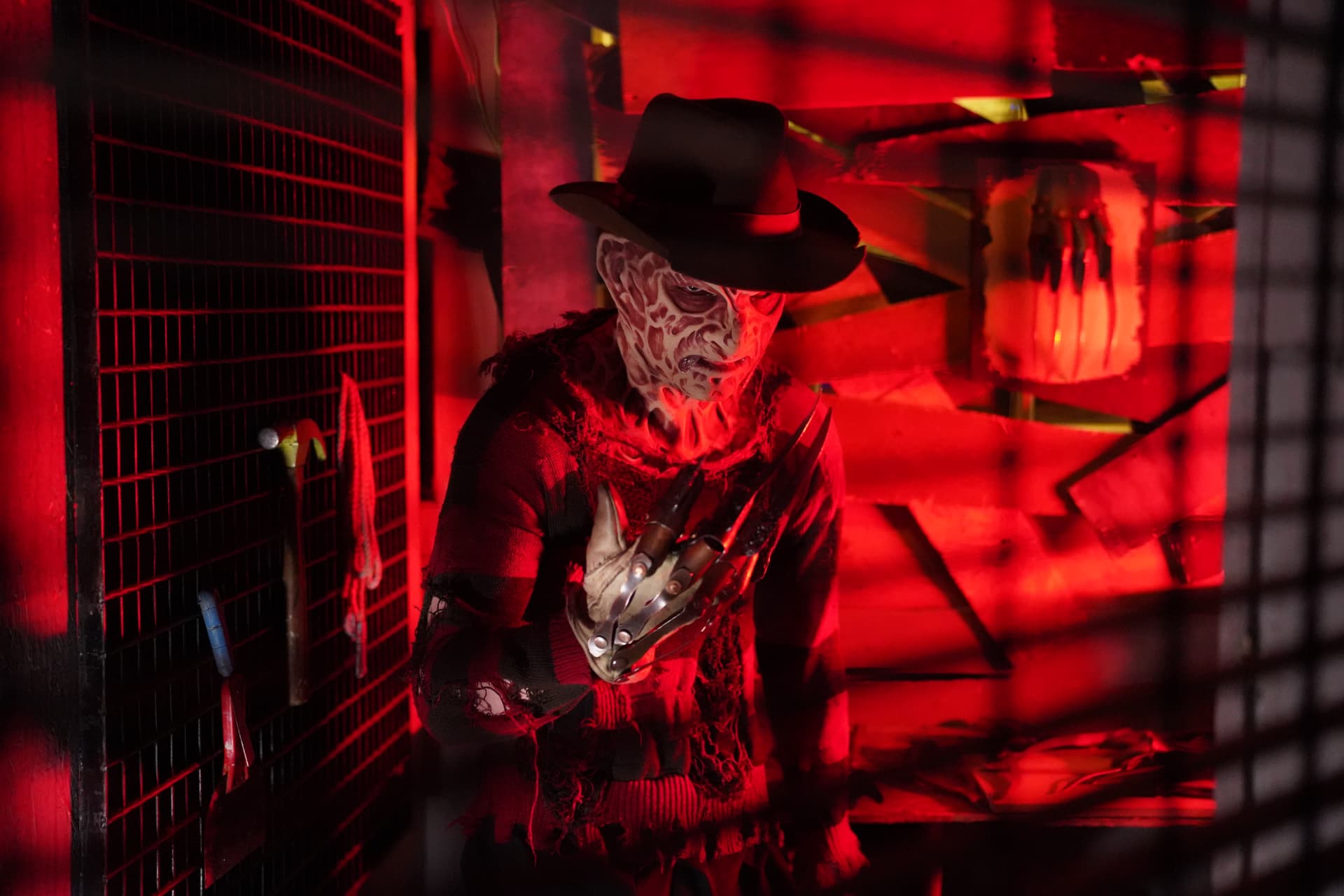 Costumed actor stalking a red-lit corridor at Castle of Chaos